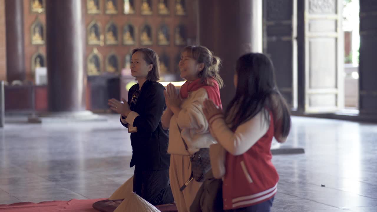 亚洲华人妇女和女儿在蔡白定佛塔与导游一起祈祷视频下载