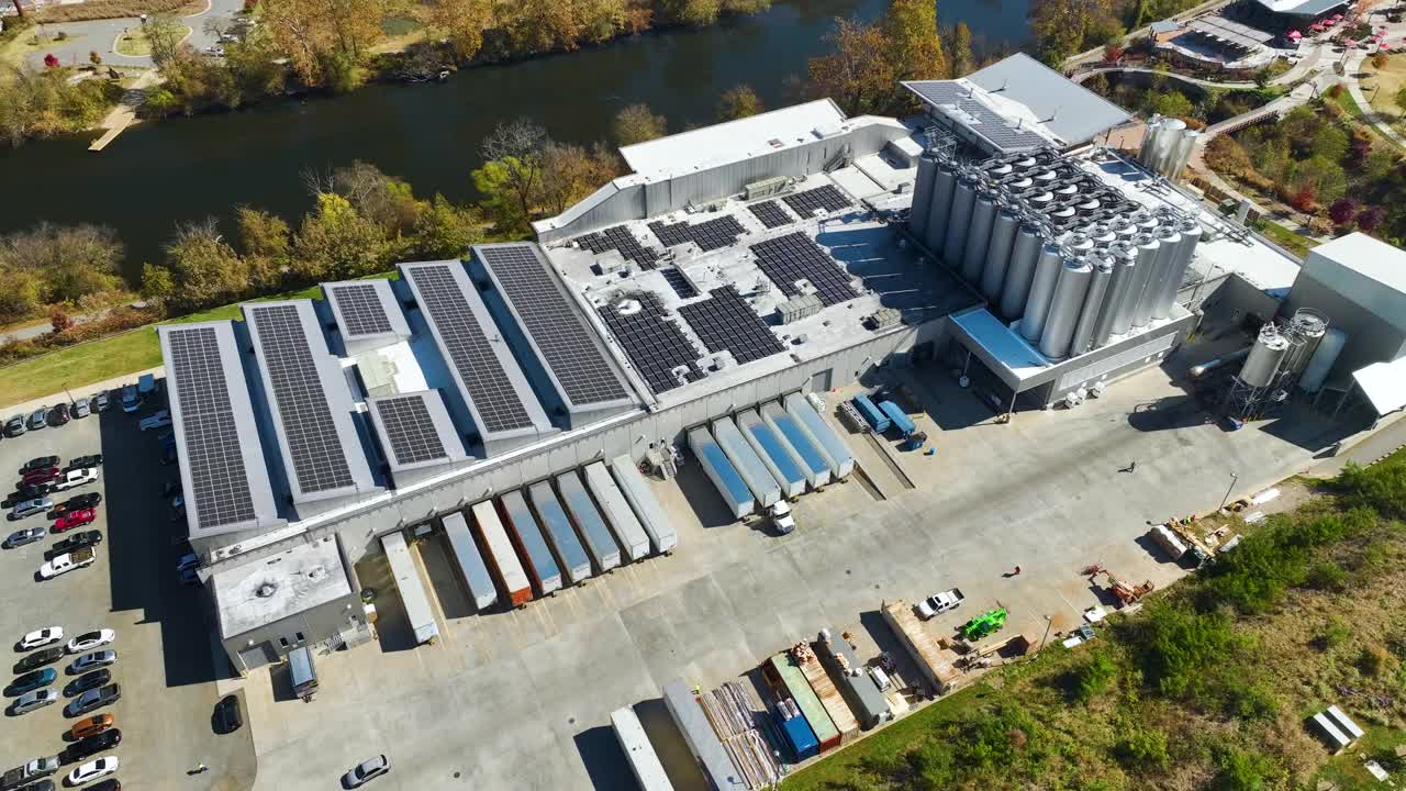 光伏太阳能电池板安装在工业建筑屋顶生产绿色生态电力鸟瞰图。生产可持续能源的概念视频素材