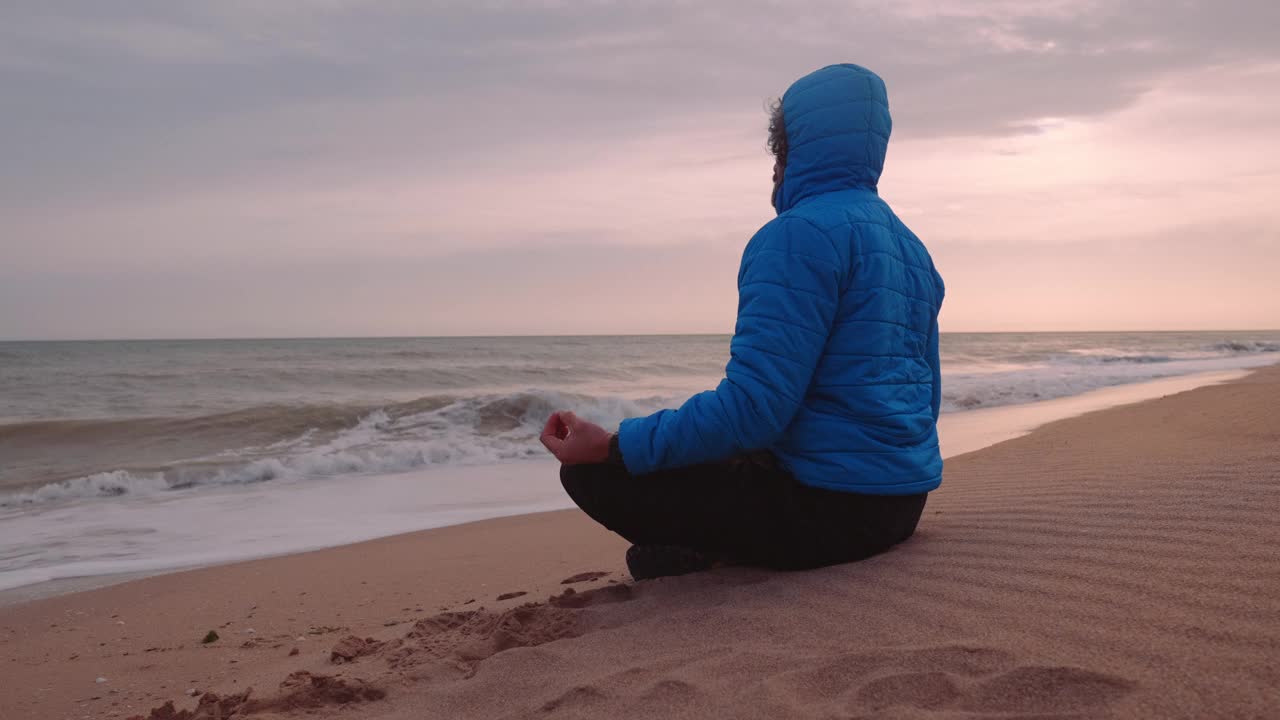 人与自然。男子在海边冥想。视频下载