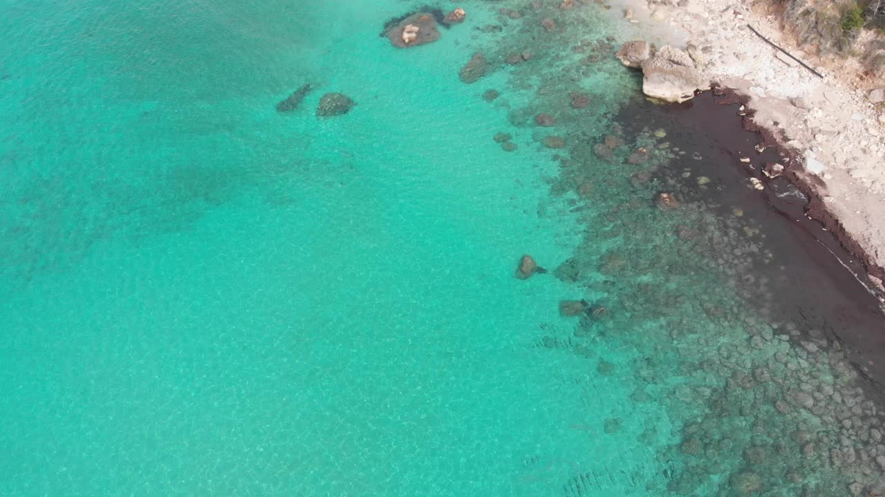 鸟瞰希腊美丽的空海滩，没有人。爱奥尼亚莱夫卡达岛戏剧性的海岸线风景海湾岩石悬崖。碧蓝碧绿的海浪。视频素材