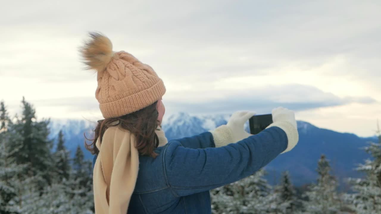 穿着外套和帽子的女人在山林中行走，与自然融为一体，慢镜头，罗马尼亚，喀尔巴阡山脉。旅人，游客，愉悦，放松。用手机拍摄全景视频下载