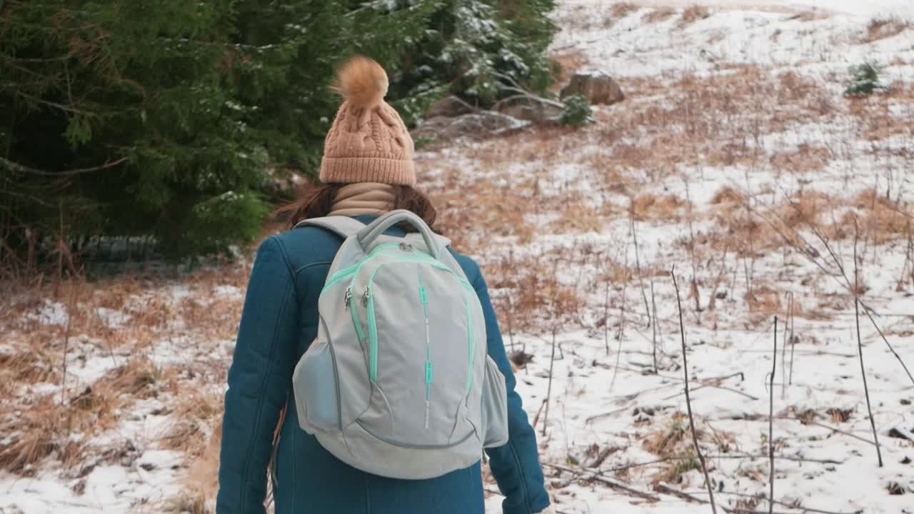 穿着外套和帽子的女人在山林中行走，与自然融为一体，慢镜头，罗马尼亚，喀尔巴阡山脉。旅人，游客，愉悦，放松。上升视频下载