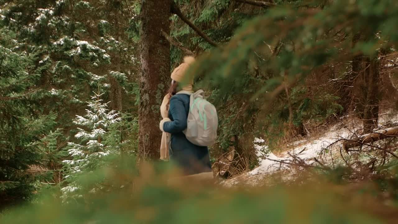 穿着外套和帽子的模糊女人在山中穿过森林，与自然融为一体，慢镜头，罗马尼亚，喀尔巴阡山脉。旅人，游客，愉悦，放松。视频下载