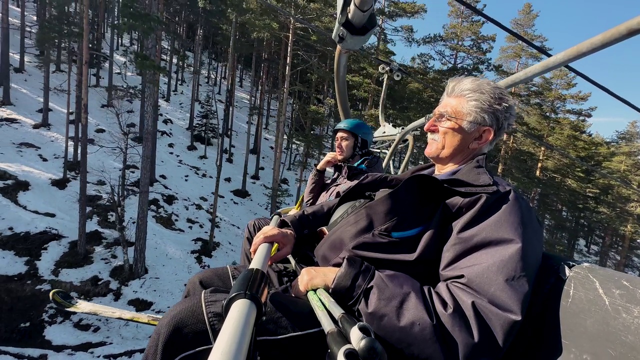 白人老人和他的孙子一起在滑雪缆车上聊天视频下载
