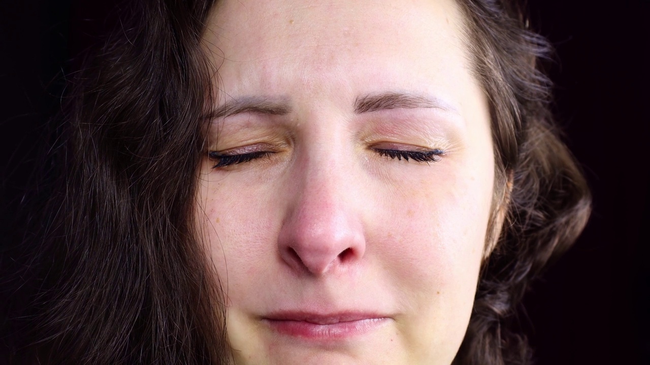 心烦意乱和沮丧的白种人黑发女子哭着用眼泪把脸拉近视频素材