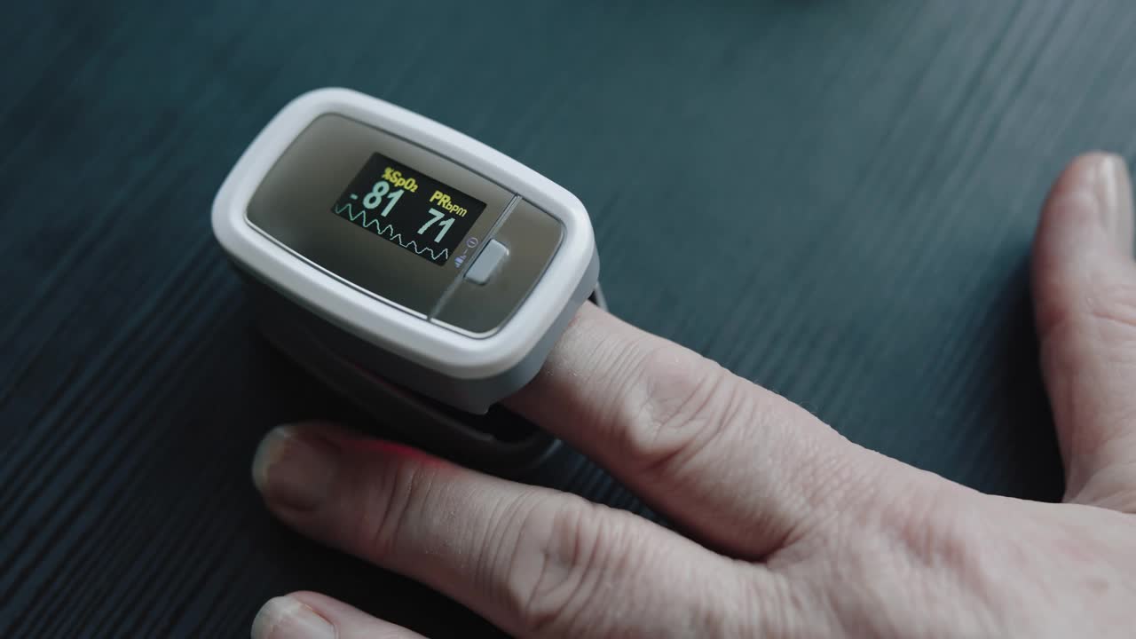 近距离视频使用指尖脉搏血氧计在手指上的血氧在家里4K股票视频视频下载