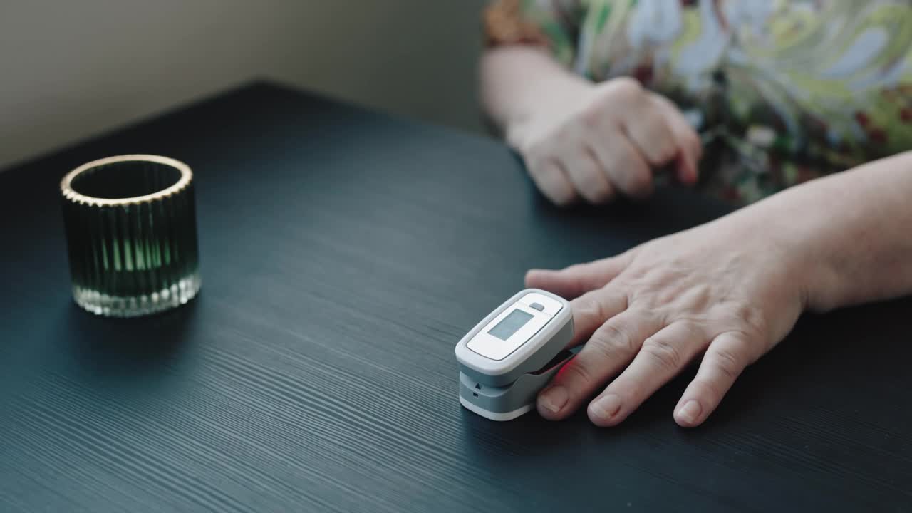 近距离视频使用指尖脉搏血氧计在手指上的血氧在家里4K股票视频视频下载