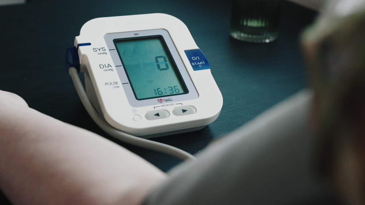 年长的退休妇女在家里用数字测量设备4k库存视频检查血压视频下载
