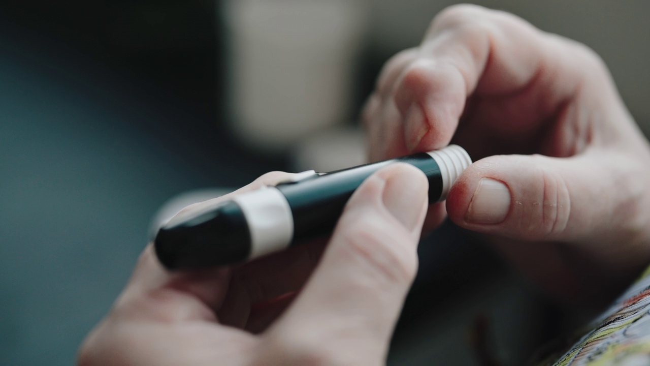 老年妇女检查血糖与糖尿病使用血糖仪在家里测试血糖4k库存视频视频下载