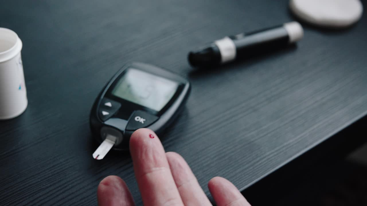 老年妇女检查血糖与糖尿病使用血糖仪在家里测试血糖4k库存视频视频下载