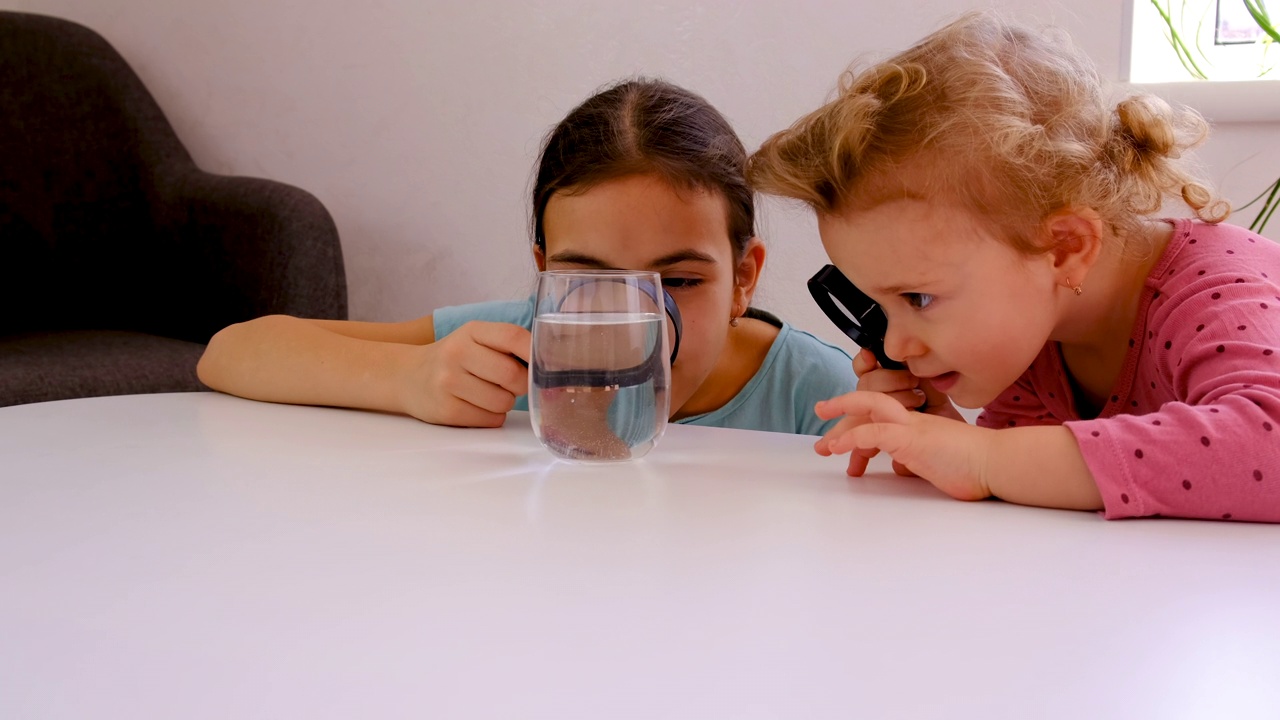 那孩子用放大镜观察水。有选择性的重点。孩子。视频下载