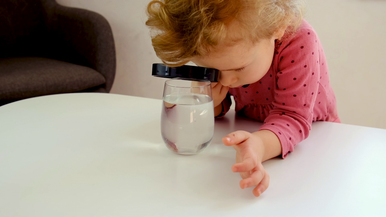 那孩子用放大镜观察水。有选择性的重点。孩子。视频下载