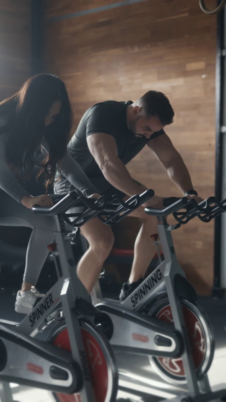 SLO MO健身夫妇在健身房锻炼自行车视频下载