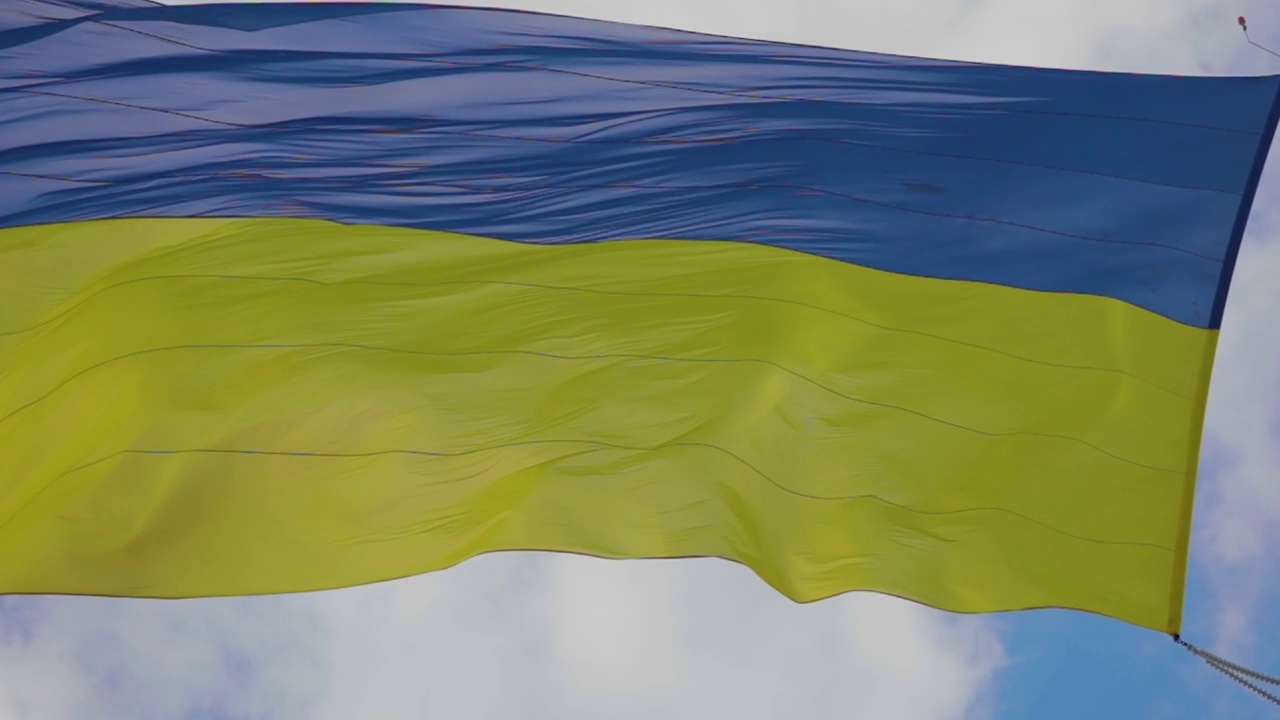乌克兰国旗在风中飘扬。乌克兰果馅饼在风中特写。乌克兰国旗映衬着天空视频下载