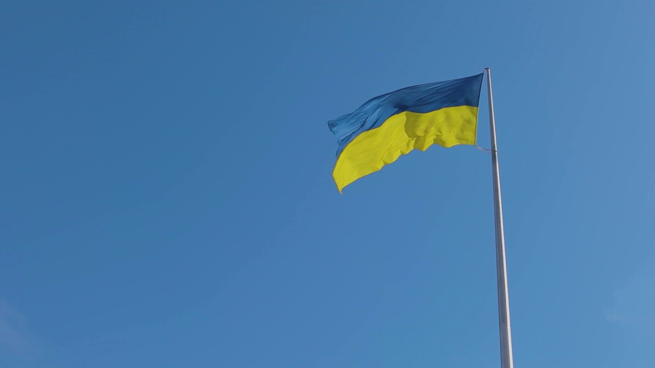 风中飘着乌克兰果馅饼。乌克兰国旗迎风飘扬。乌克兰国旗映衬着天空视频下载