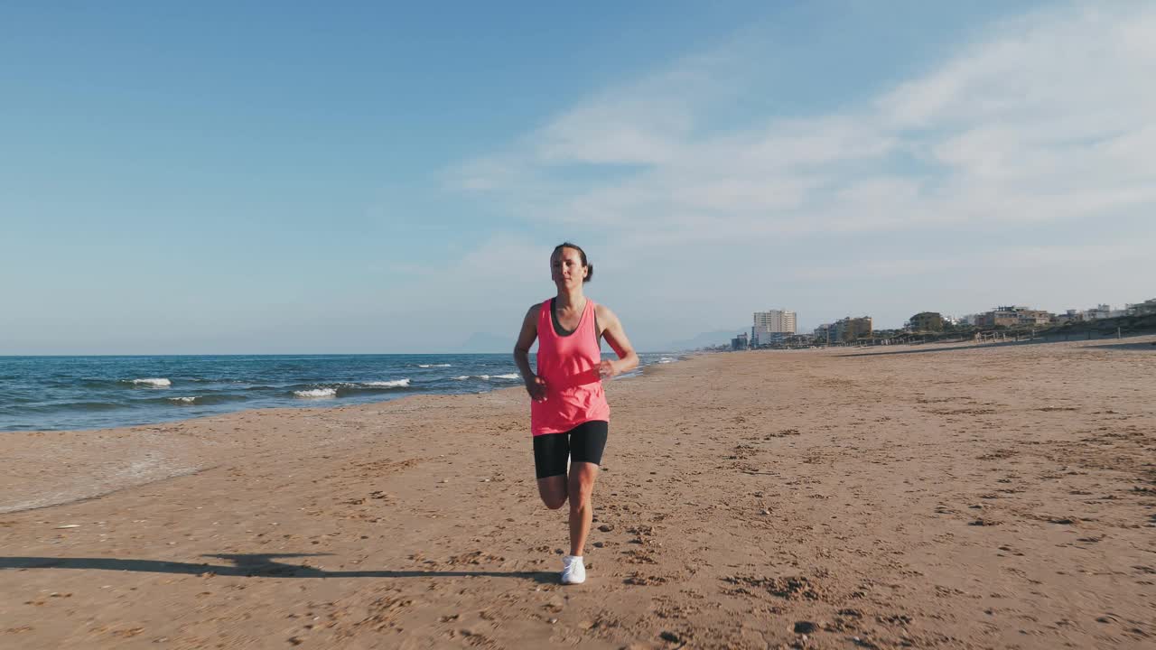 积极健康的生活方式理念。年轻自信的女人在海边奔跑视频下载