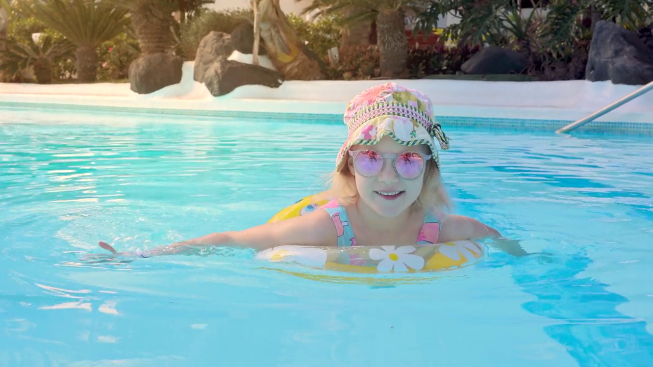 快乐的孩子在游泳池充气环在度假酒店水上乐园视频购买