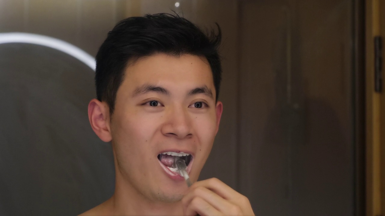 英俊的亚洲男人晚上刷牙视频下载