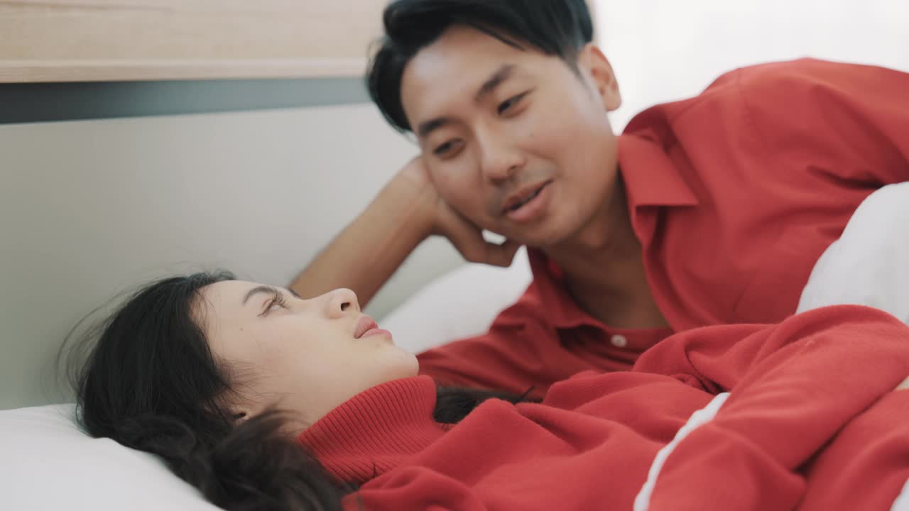 年轻爱幸福爱微笑的已婚夫妇躺在床上一起玩视频素材