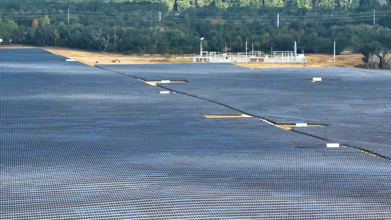 大型可持续发电厂鸟瞰图，有许多排太阳能光伏板，用于生产清洁电能。零排放概念的可再生电力视频素材