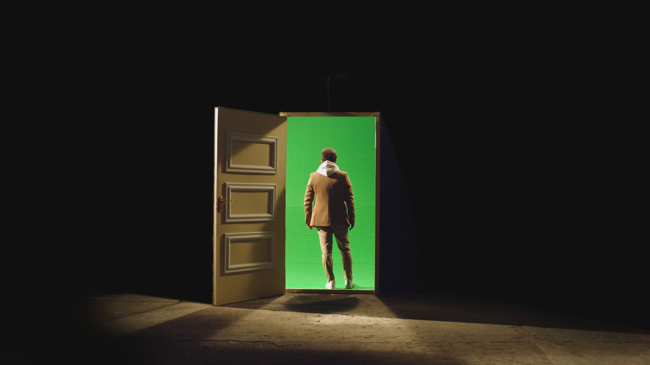 4K背影的人走在前面的一扇敞开的门后面的黑暗。商人走在地板附近的绿色屏幕门的镜头。匿名的概念，商业梦想或瞬间移动视频下载