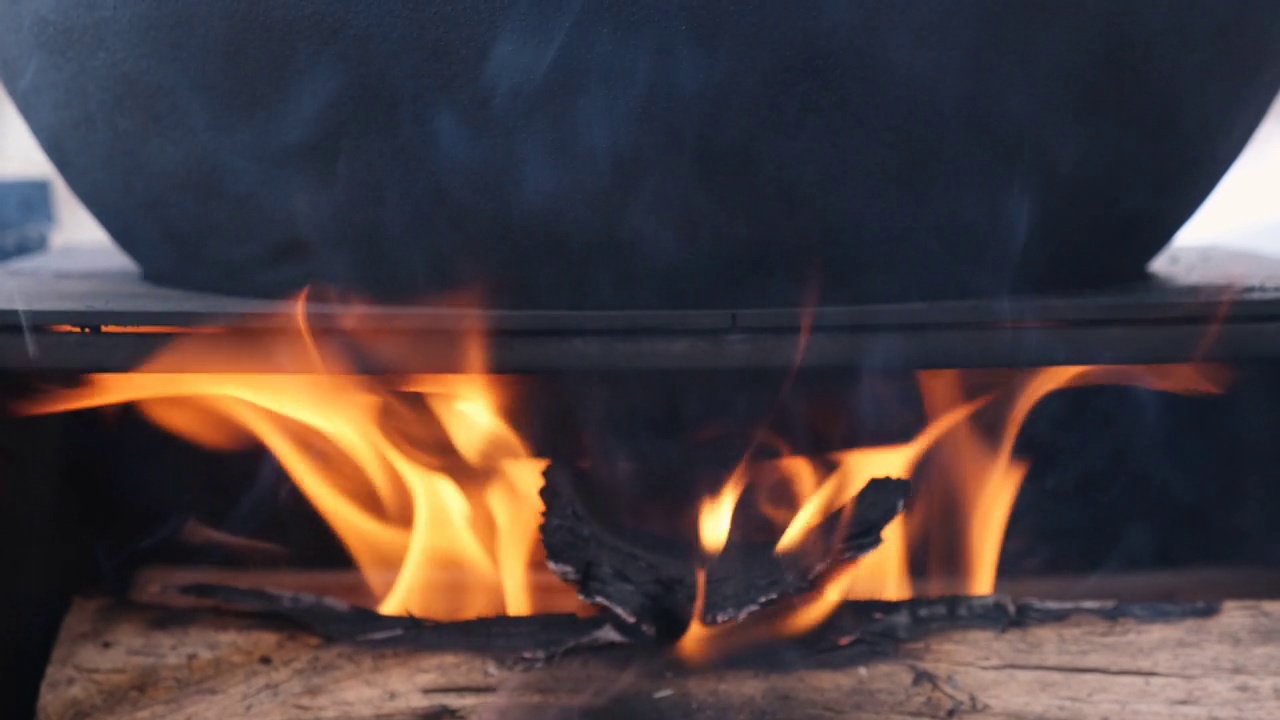 登山锅特写，鲍勒在篝火里的大锅里火刑。旅行，旅游，野餐烹饪，在大锅的木桩上烹饪，火和烟。视频素材