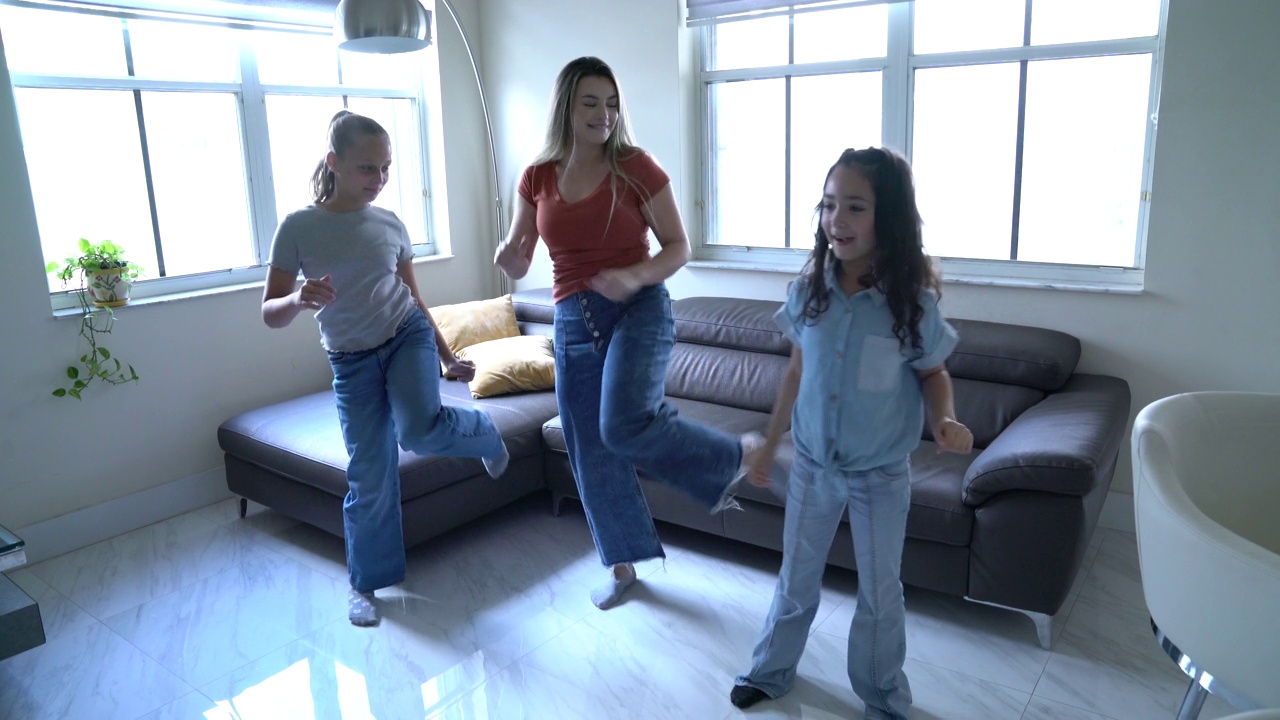 母亲带着女儿和朋友在客厅愉快地练习编舞视频下载