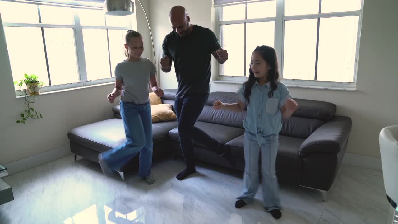 拉丁裔父亲带着女儿和朋友在客厅随着音乐起舞视频下载