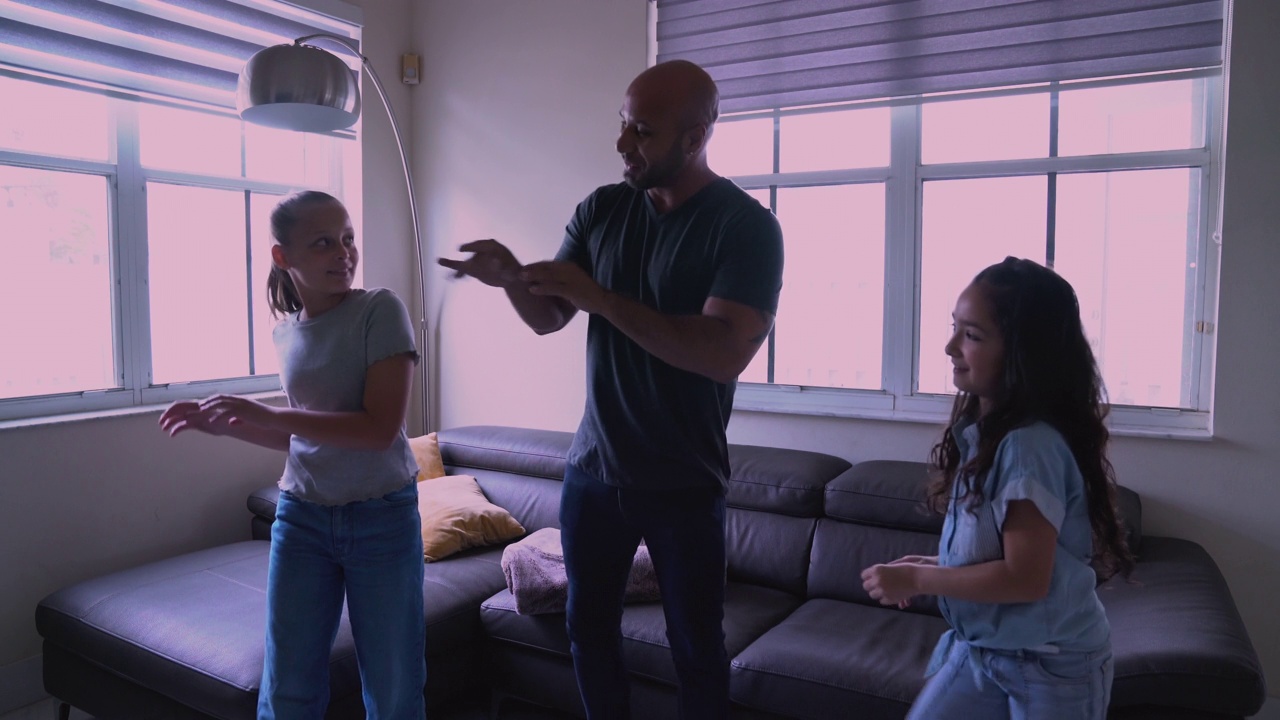 拉丁裔父亲带着女儿和朋友在客厅随着音乐起舞视频下载