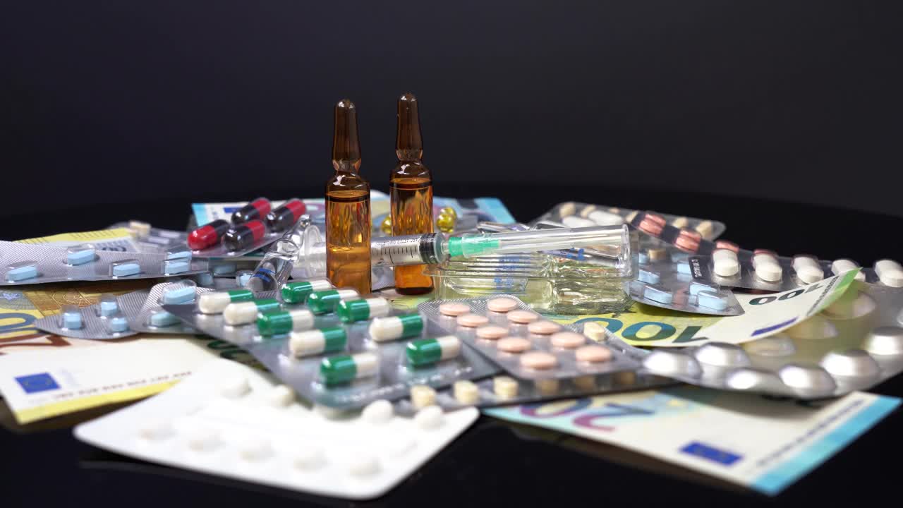 药品成本的上升-在起泡包装的药丸，安瓿药物和注射器在欧元钞票上。视频素材