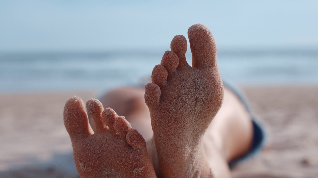 近距离女子脚放松在海滩游客享受温暖的暑假在热带海滨视频下载