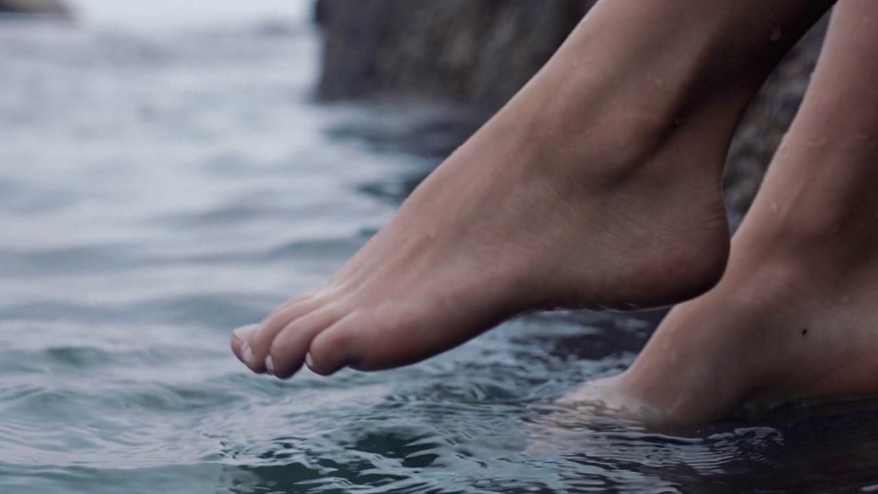 近距离女子脚玩水，赤脚享受平静的海滩视频下载