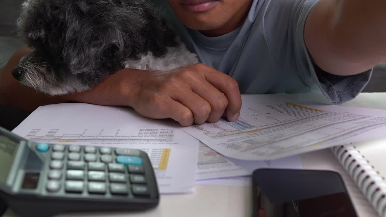 一个商人在家里带着狗在笔记本电脑上工作视频下载