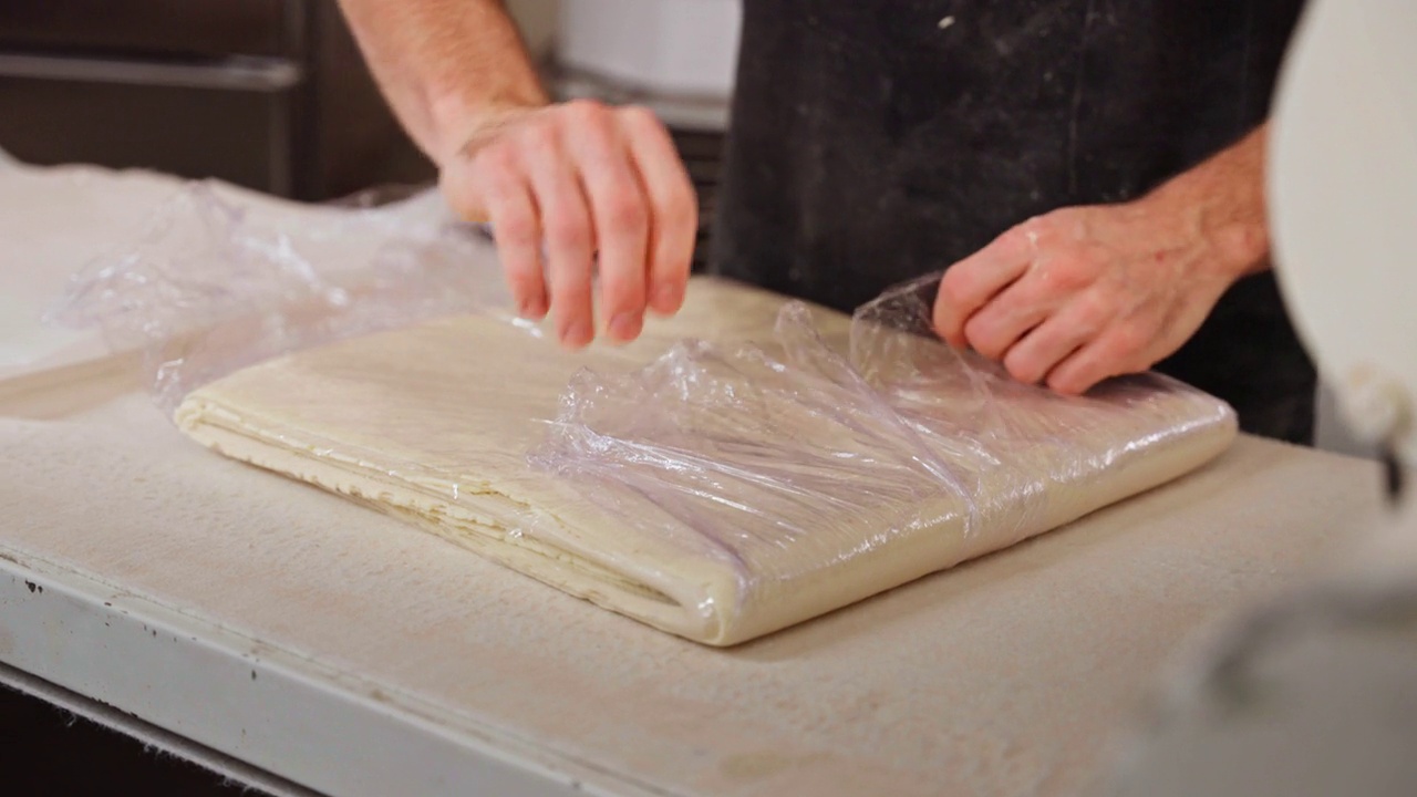 白人面包师用塑料箔包面团视频素材