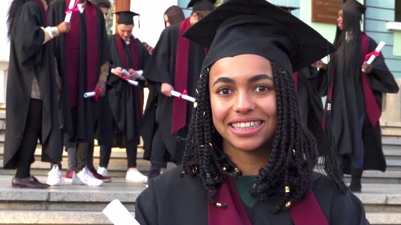 一名毕业生自豪地拿着她的毕业证书视频素材