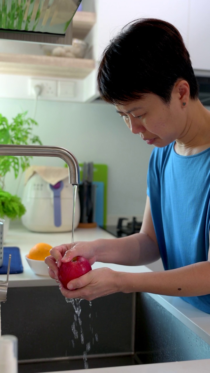 一个亚洲女人在洗苹果视频素材