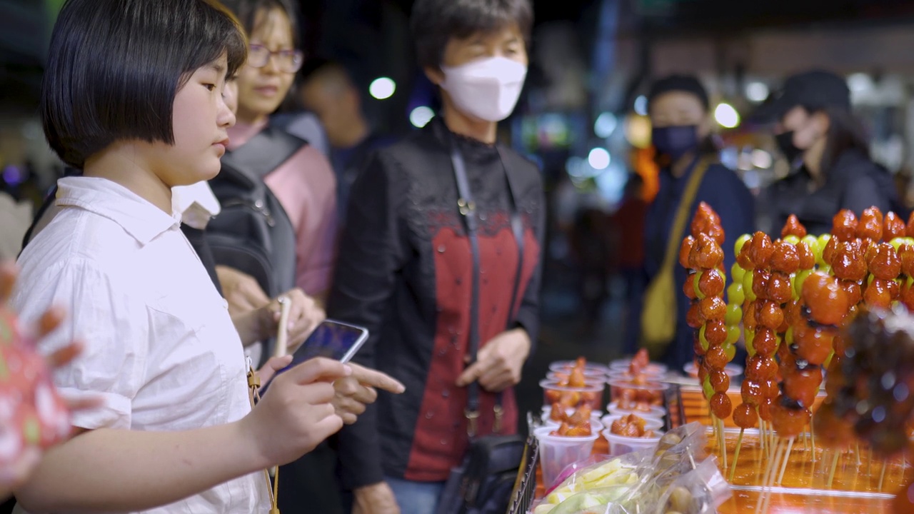 亚洲华人家庭游客在台湾夜市发现街头小吃视频素材