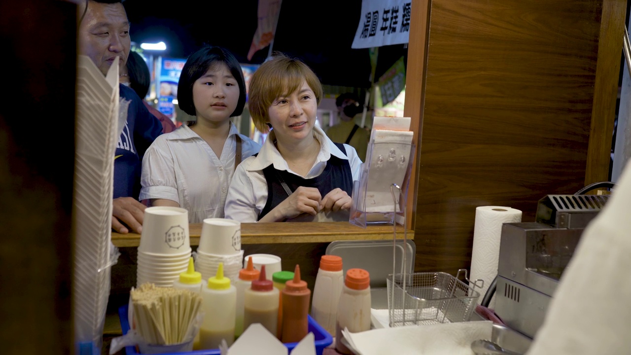 亚洲华人家庭游客在台湾夜市发现街头小吃视频下载
