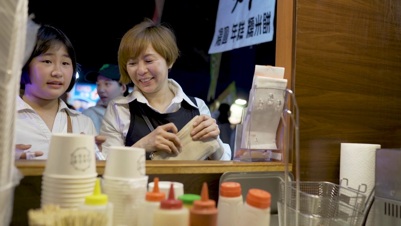 亚洲华人家庭游客在台湾夜市发现街头小吃视频素材