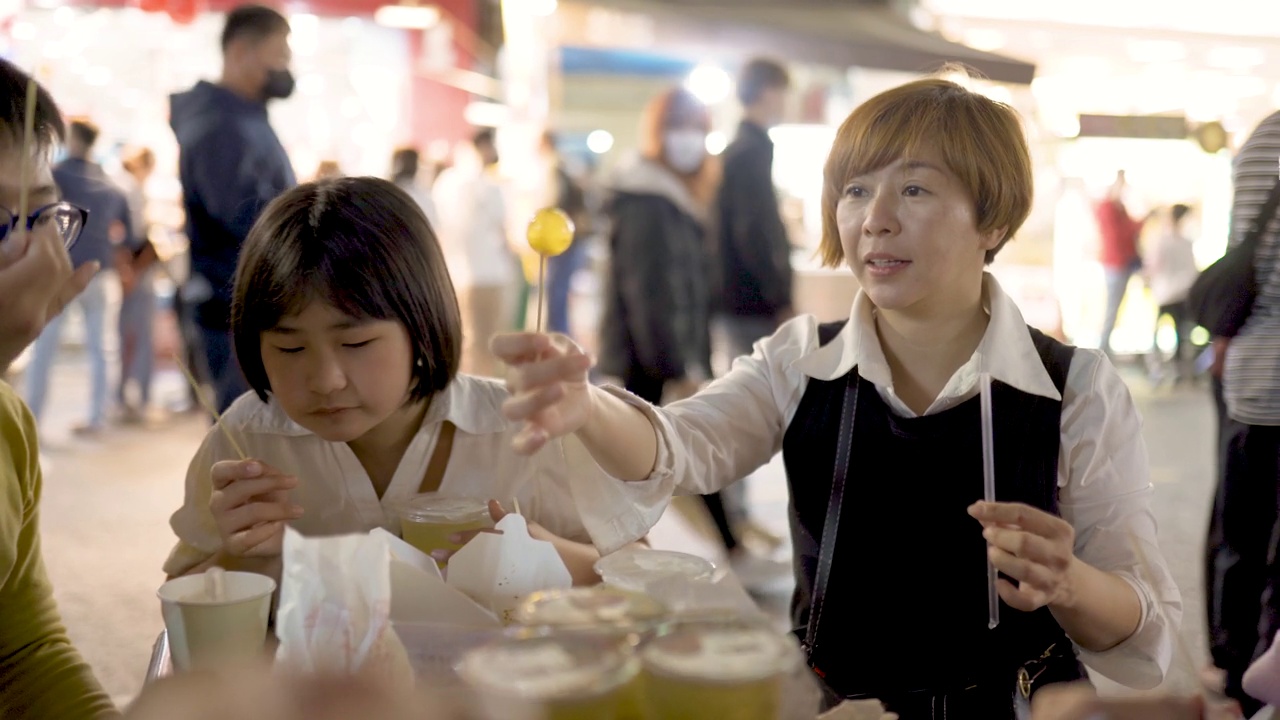 亚洲华人家庭游客在台湾夜市享受街头小吃视频素材