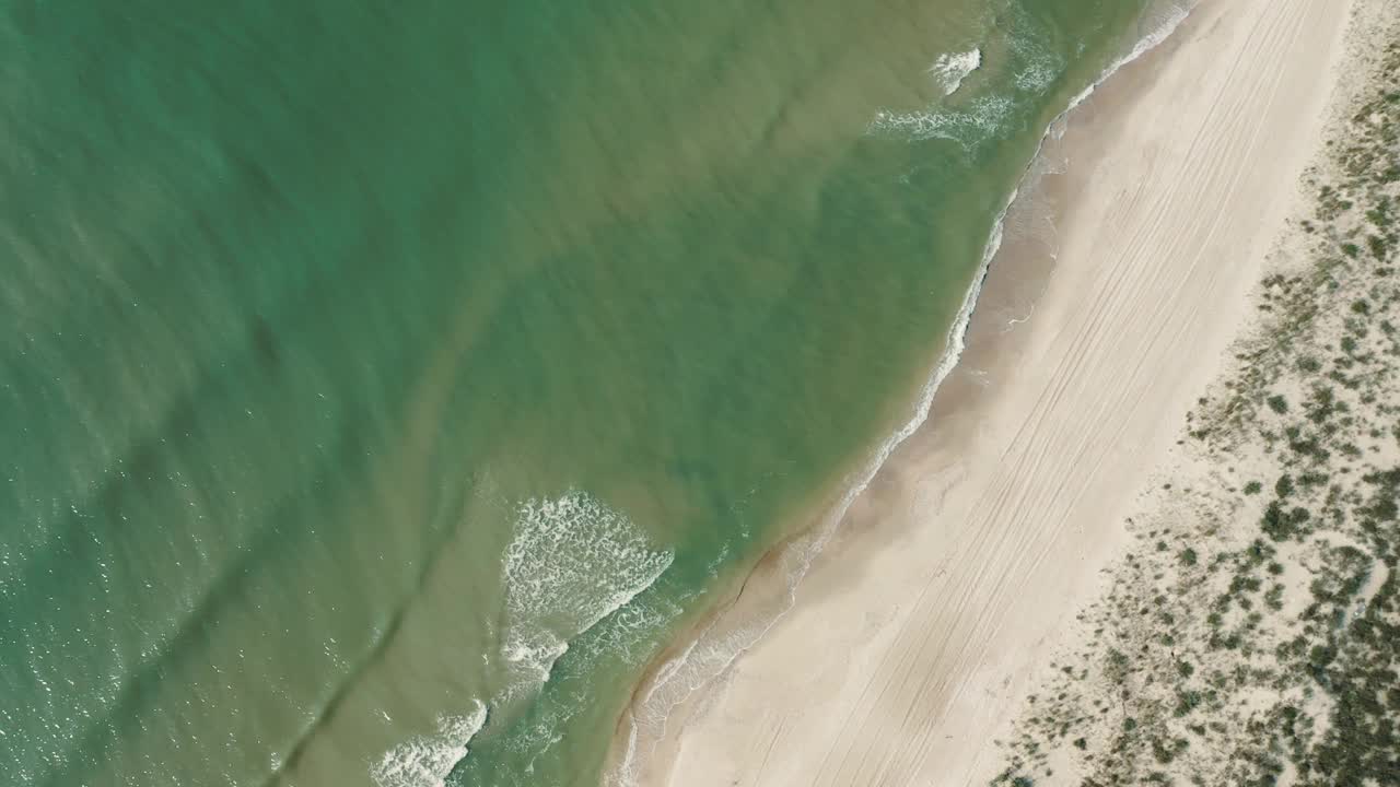 一个阳光明媚的夏日，海洋海岸线表面的鸟瞰图。视频下载