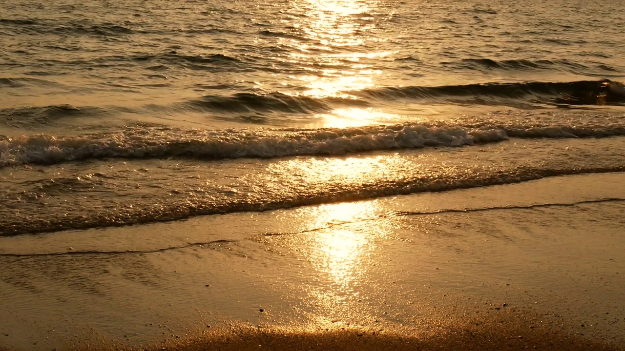 热带海滩上4K惊人的日落。日落时分，海浪拍打着海滩，阳光反射在水面上。美丽的傍晚自然大海背景。视频下载