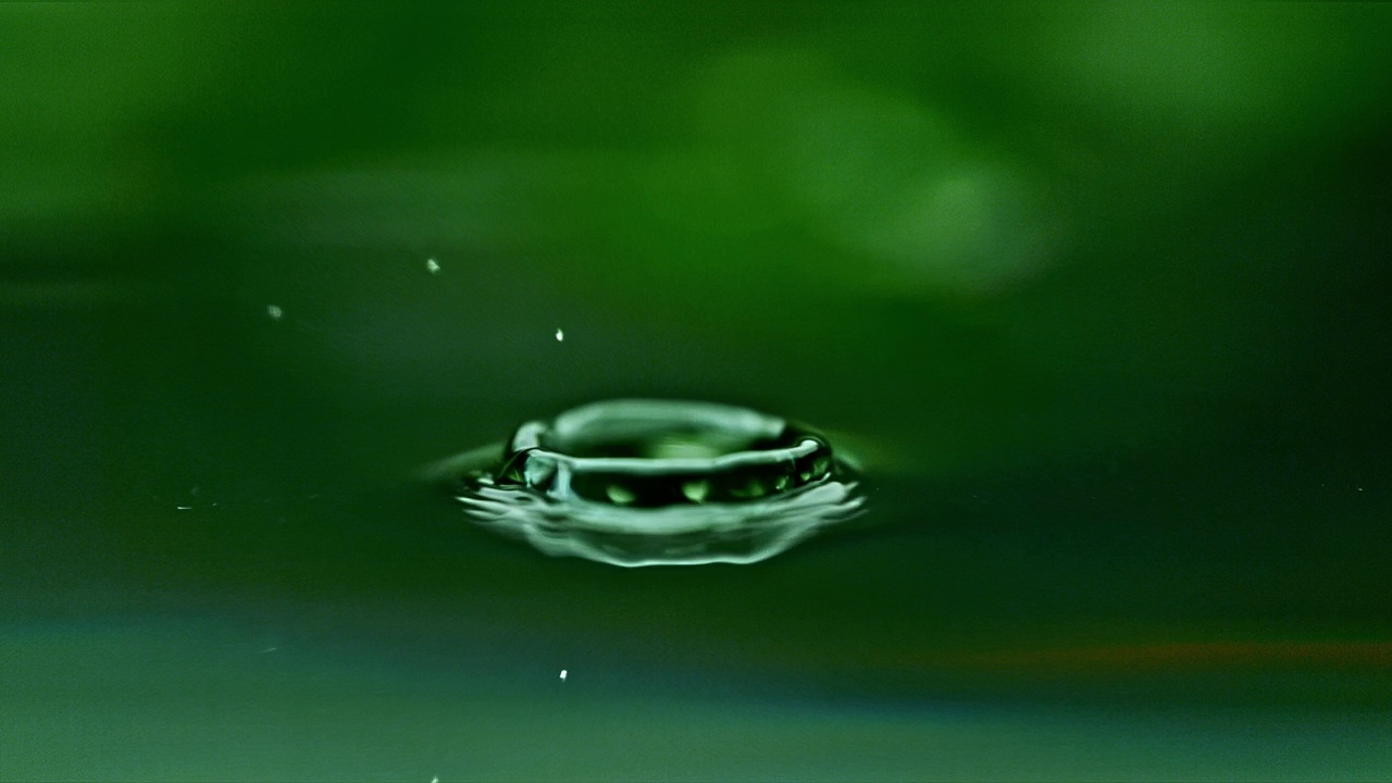 超级SLO MO极端接近雨滴荡漾绿色水面视频下载