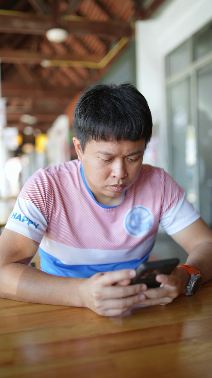 担心的亚洲男子正在使用智能手机。视频下载