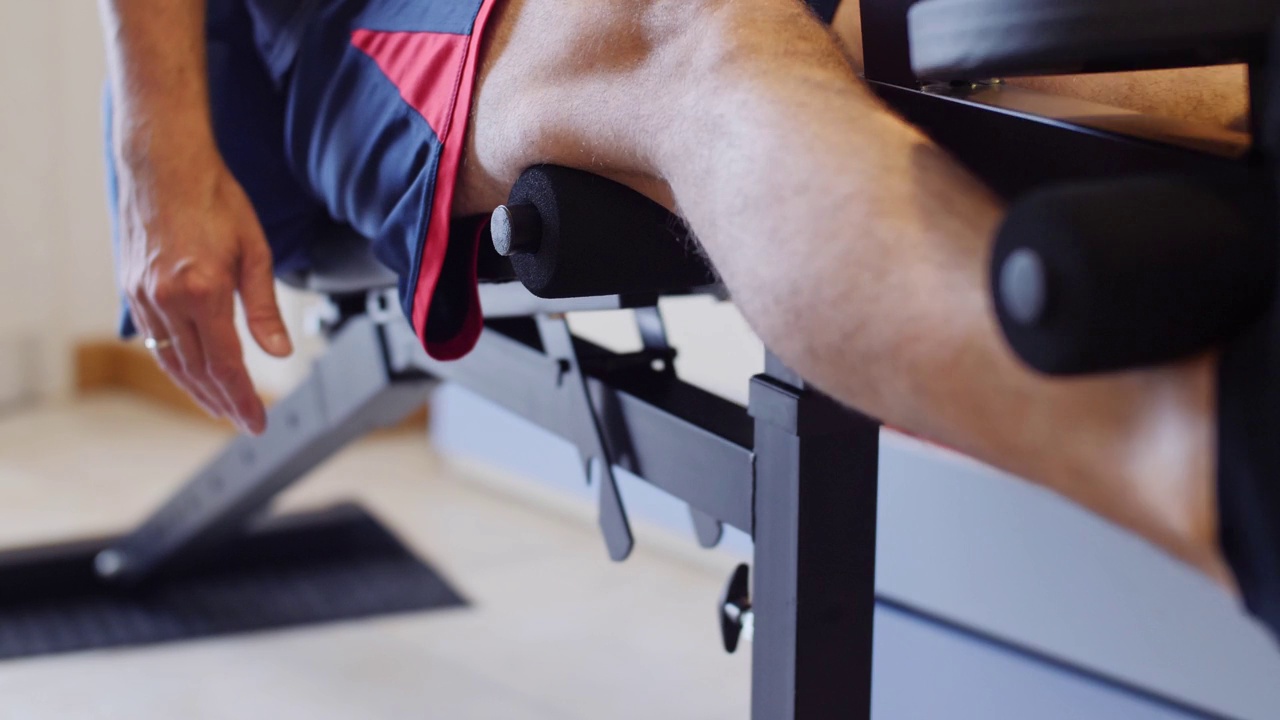 做健身运动:在腿部器械上进行腿部伸展训练视频下载