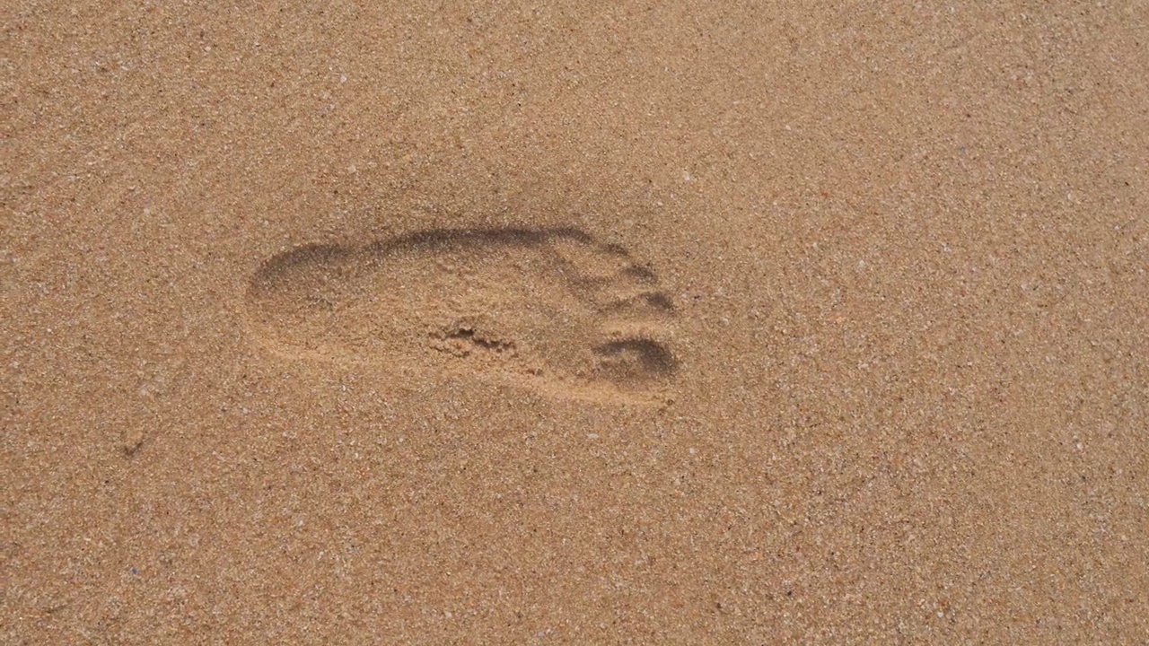 沙滩上的脚印被海浪冲走了。视频下载