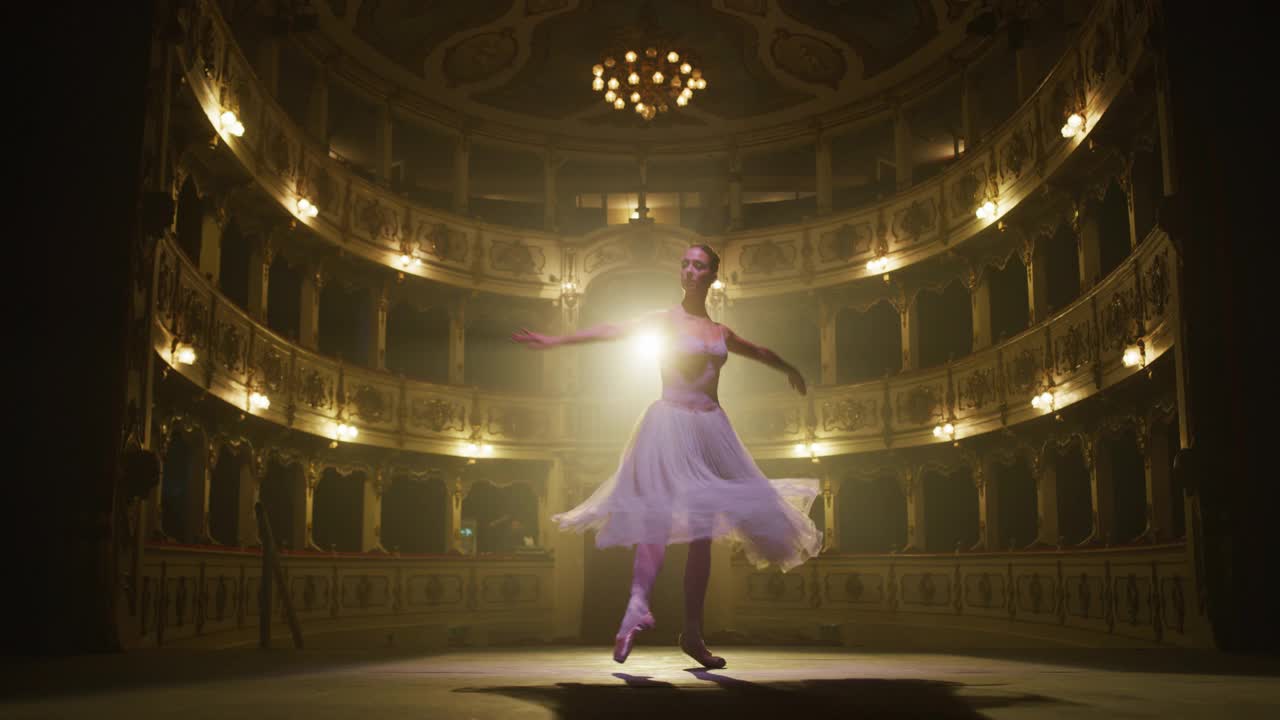 芭蕾舞女演员在足尖鞋和白色芭蕾舞裙跳舞和排练的慢动作镜头与戏剧灯光的经典剧院舞台。优雅的古典芭蕾舞女舞者表演舞蹈视频下载