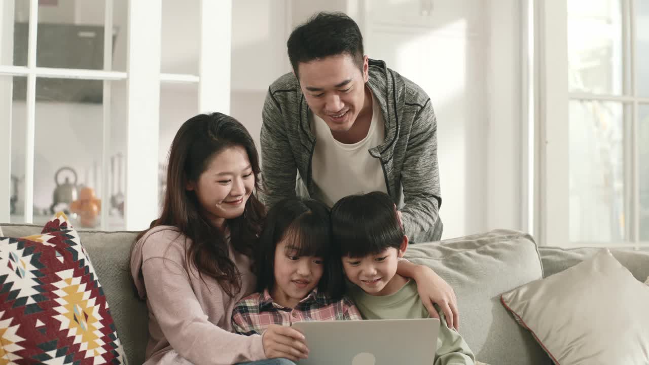 亚洲夫妇和孩子在家里一起使用笔记本电脑视频素材