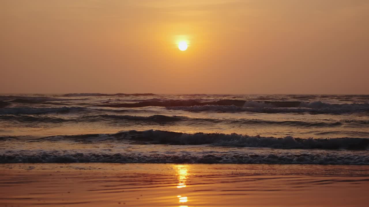 海浪在日出时撞击海岸的广角镜头。慢镜头视频素材