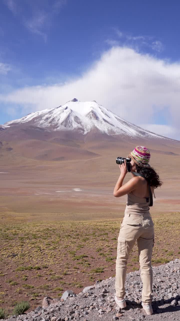 女旅游摄影师在安托法加斯塔地区los flamencos国家保护区的altiplano雪山拍摄照片视频下载